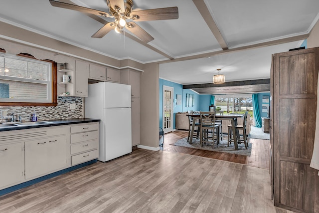 kitchen featuring white cabinetry, white fridge, light wood-type flooring, and sink