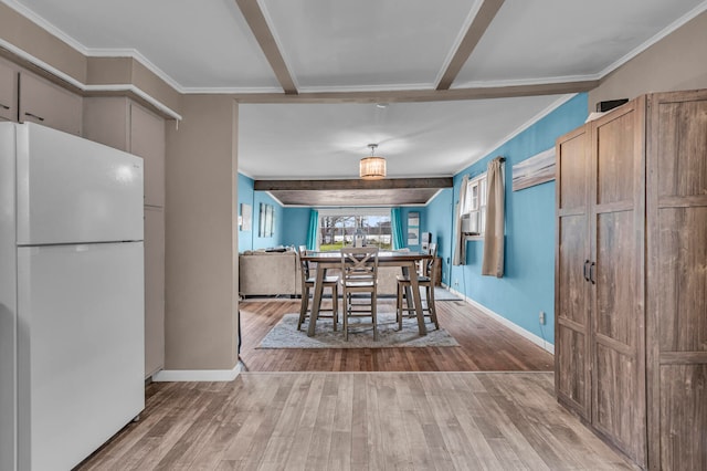 unfurnished dining area with ornamental molding, beamed ceiling, and light hardwood / wood-style floors