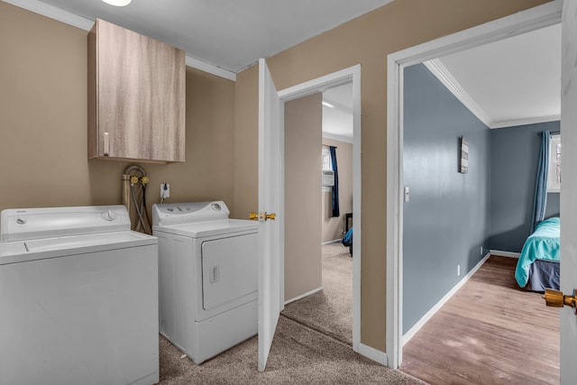 washroom with light wood-type flooring, washing machine and clothes dryer, and ornamental molding