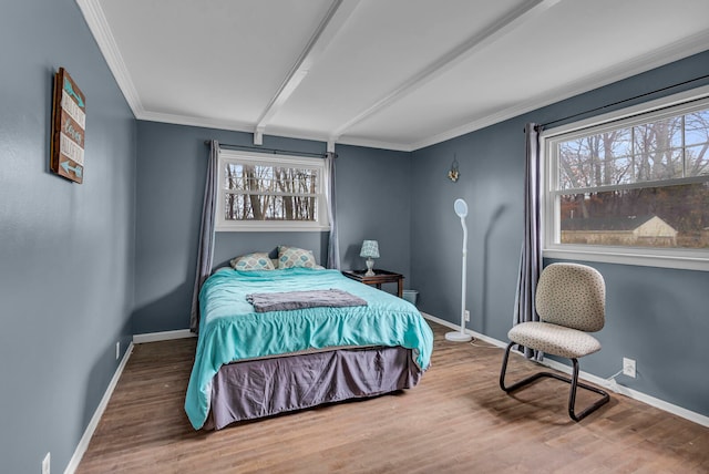 bedroom with ornamental molding, hardwood / wood-style floors, and multiple windows