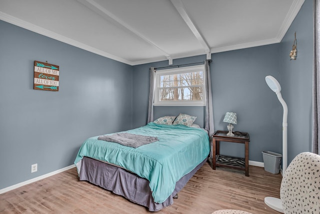 bedroom with ornamental molding and light hardwood / wood-style floors