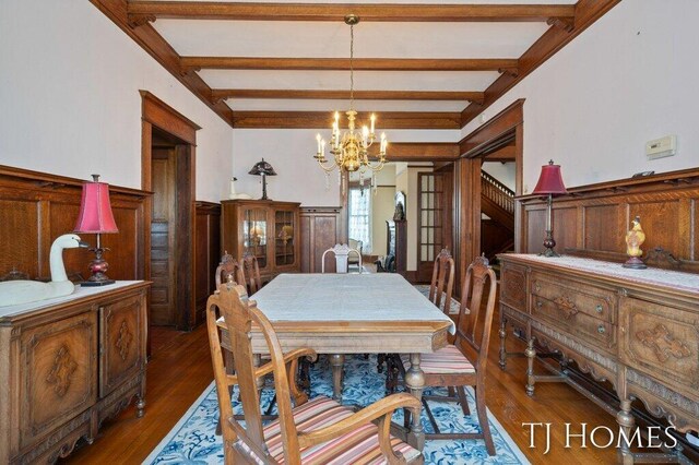 dining area featuring an inviting chandelier, dark hardwood / wood-style floors, and beam ceiling