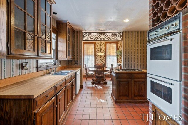 kitchen featuring sink, light tile patterned floors, and stainless steel appliances