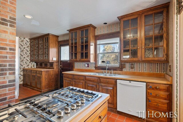 kitchen with sink, tile patterned floors, stainless steel gas stovetop, and dishwasher