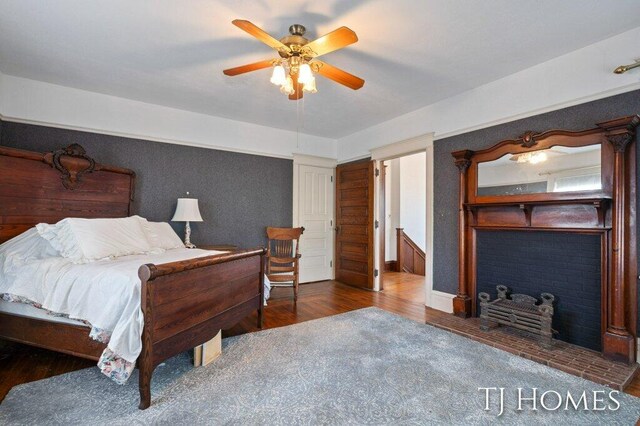 bedroom with dark hardwood / wood-style flooring and ceiling fan