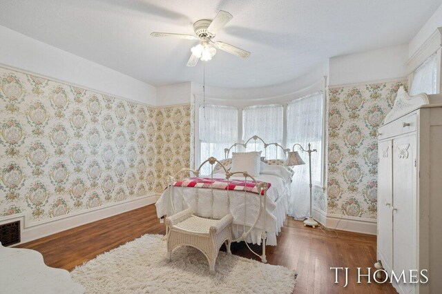 bedroom with dark hardwood / wood-style flooring and ceiling fan