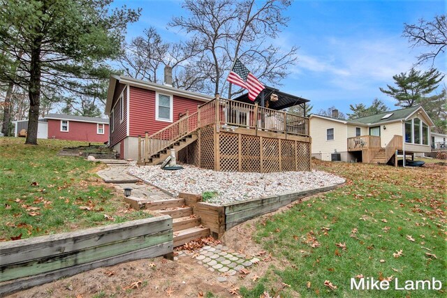 back of house with a wooden deck and a yard