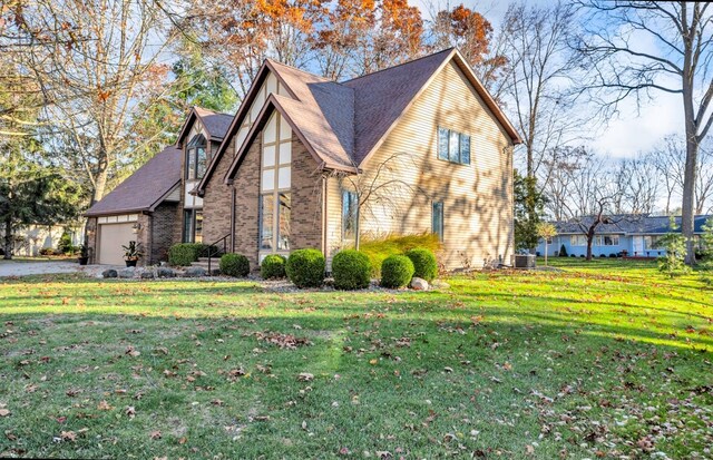 view of front of property with a garage, cooling unit, and a front yard