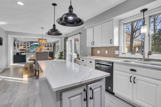 kitchen featuring sink, a center island, white cabinets, pendant lighting, and dishwasher