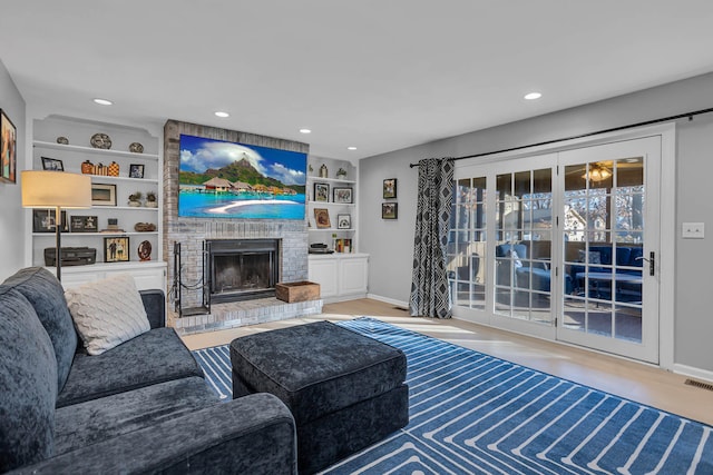 living room featuring built in features and a fireplace