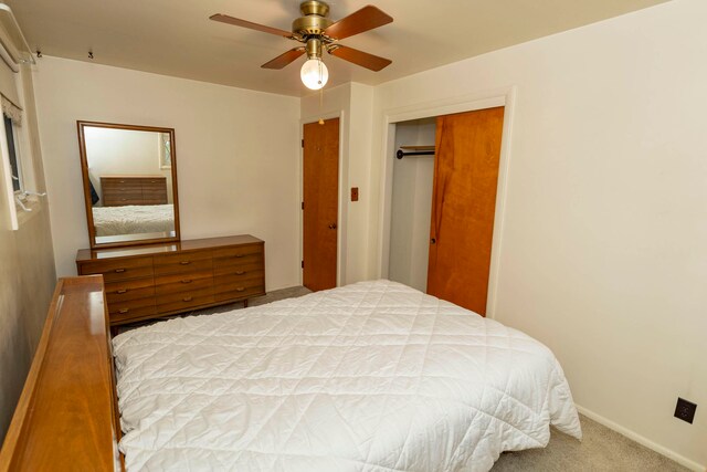 carpeted bedroom with ceiling fan and a closet