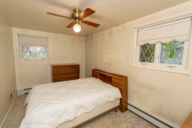 carpeted bedroom with baseboard heating and ceiling fan