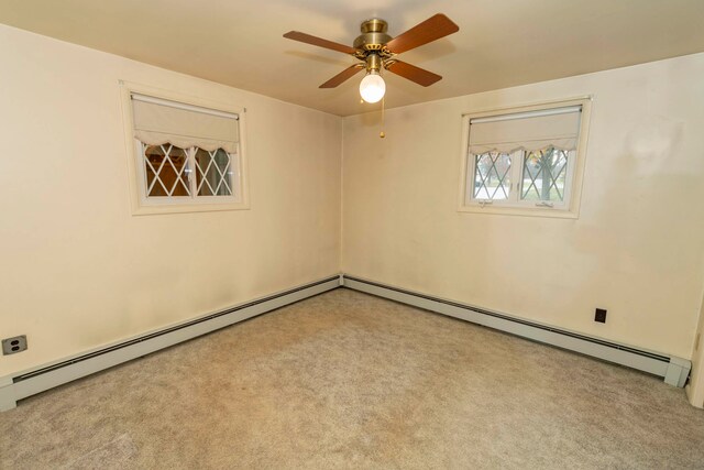 carpeted spare room featuring ceiling fan and a baseboard heating unit