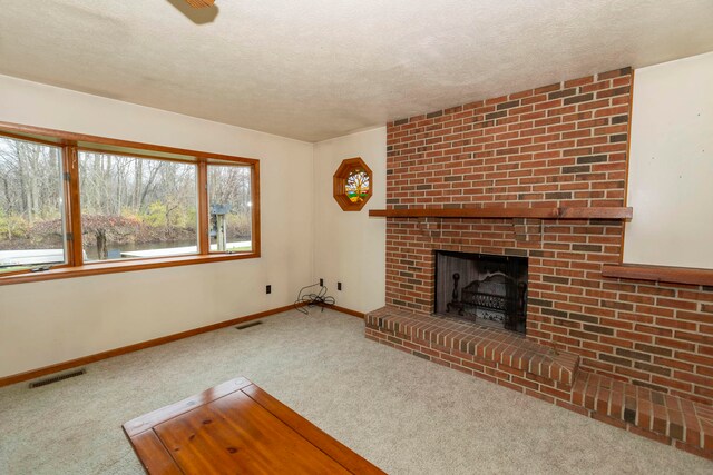 unfurnished living room with carpet floors, a textured ceiling, and a brick fireplace