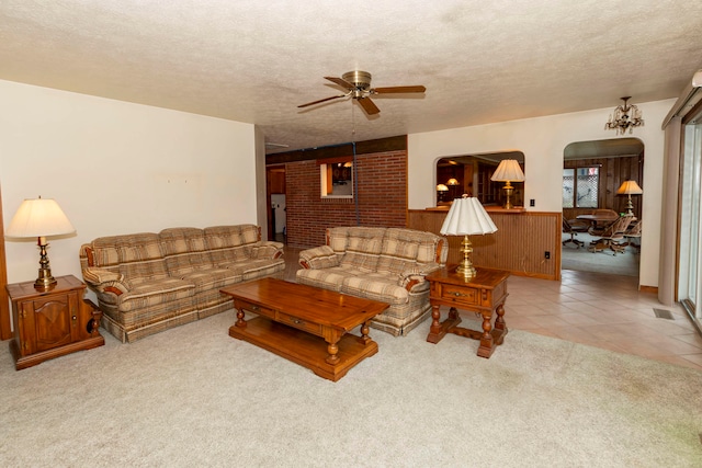 carpeted living room with ceiling fan and a textured ceiling