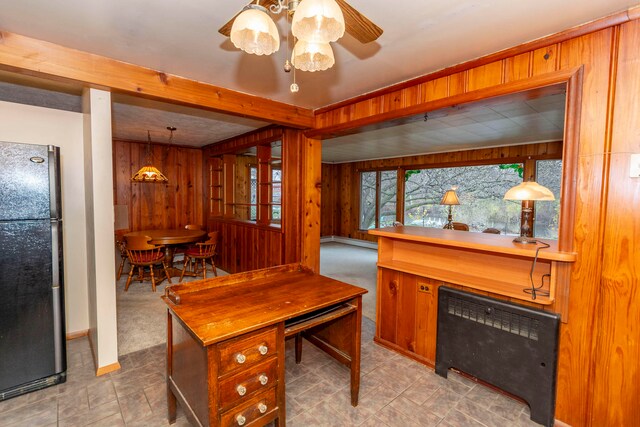 office with ceiling fan, light carpet, and wooden walls