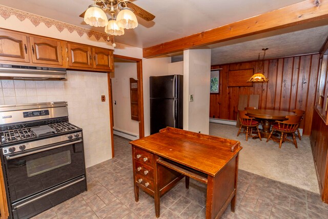 kitchen featuring wood walls, black refrigerator, a baseboard radiator, decorative light fixtures, and range with gas cooktop