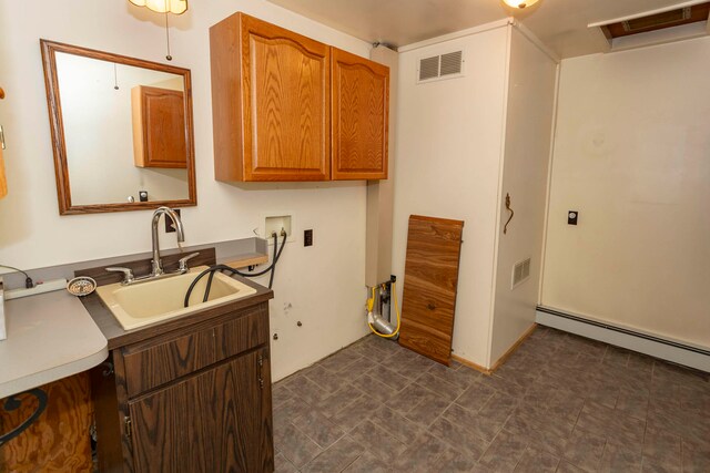 washroom with sink, cabinets, a baseboard radiator, and washer hookup