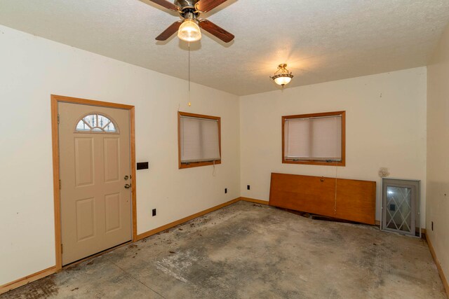 entrance foyer with a textured ceiling and ceiling fan