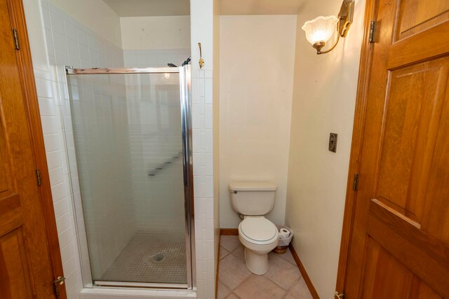 bathroom with tile patterned floors, toilet, and walk in shower