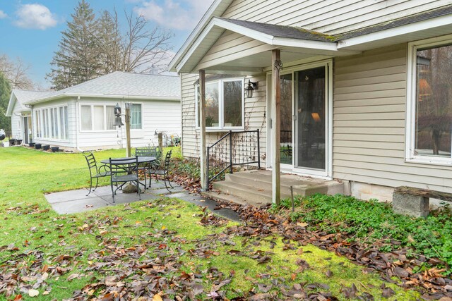 doorway to property featuring a patio area and a yard