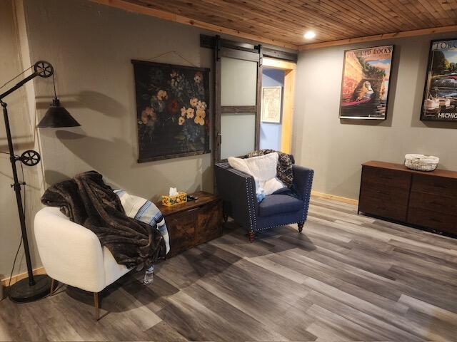 sitting room featuring hardwood / wood-style floors, a barn door, and wooden ceiling