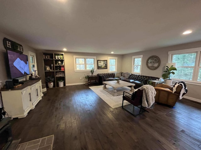 living room with a wealth of natural light and dark wood-type flooring