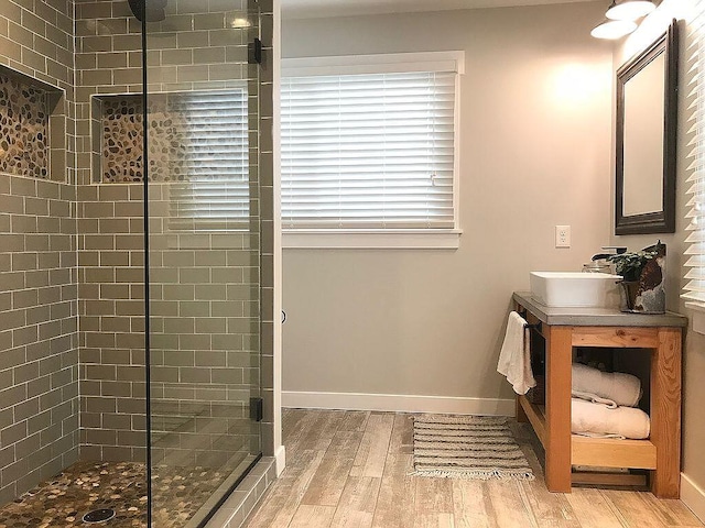 bathroom with a shower with door, vanity, and hardwood / wood-style flooring