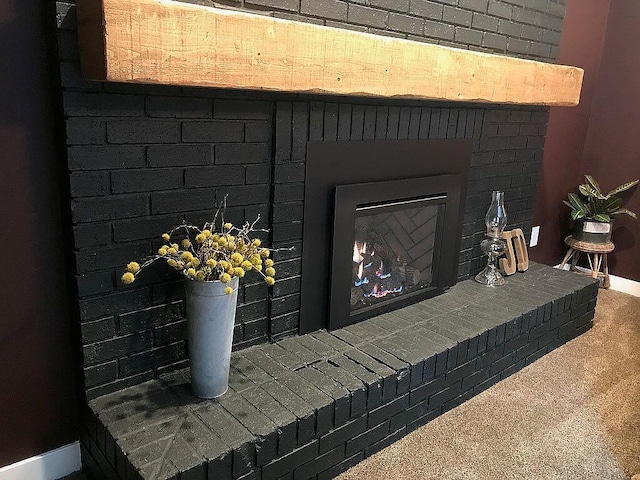 interior details with carpet floors and a brick fireplace