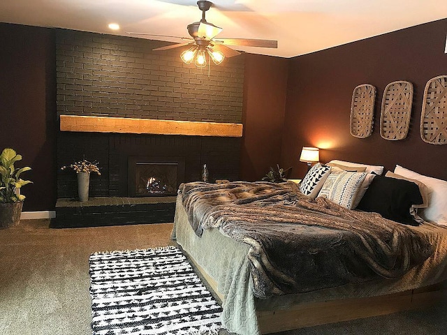 carpeted bedroom featuring ceiling fan and a brick fireplace