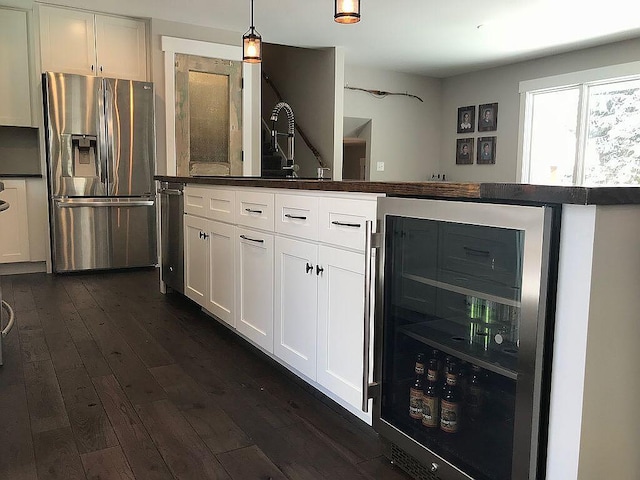 kitchen featuring beverage cooler, dark hardwood / wood-style floors, stainless steel refrigerator with ice dispenser, pendant lighting, and white cabinets