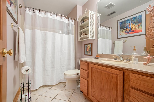 bathroom with toilet, vanity, and tile patterned floors