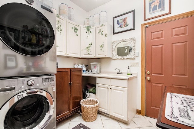 laundry area featuring cabinets, sink, stacked washer / dryer, and light tile patterned floors