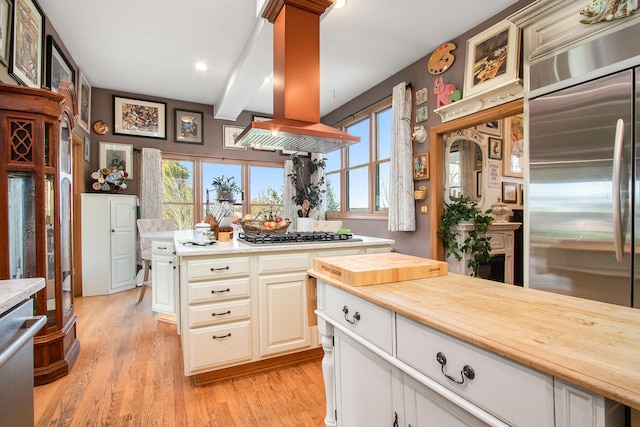 kitchen featuring wooden counters, stainless steel appliances, island exhaust hood, beam ceiling, and light wood-type flooring