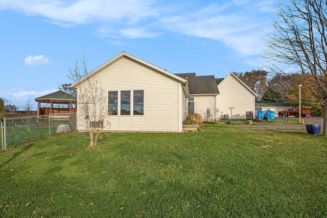 back of house with a yard and a gazebo