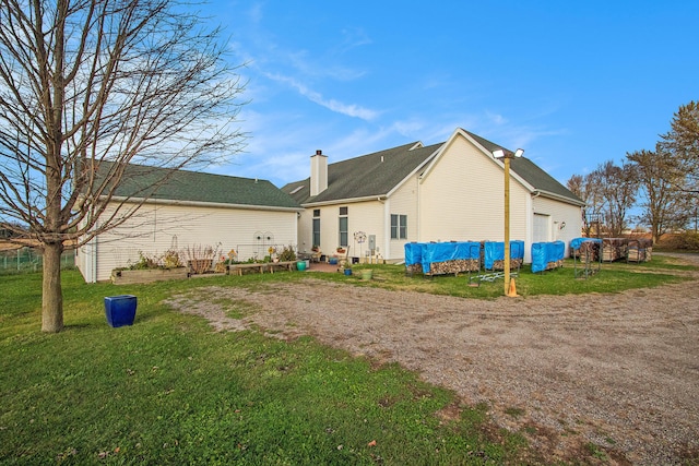 back of property with a garage and a yard