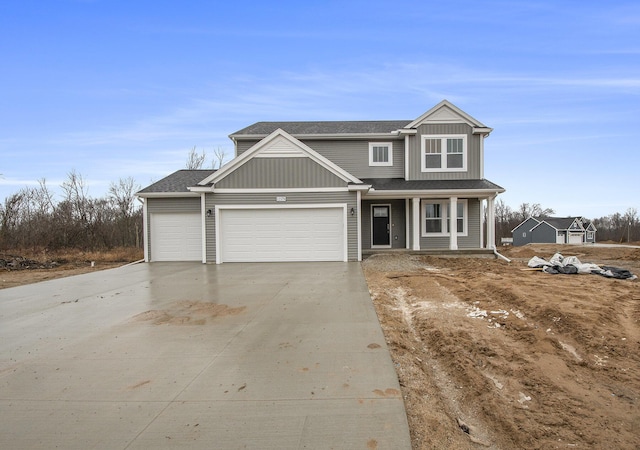 view of front facade with a garage, board and batten siding, concrete driveway, and roof with shingles