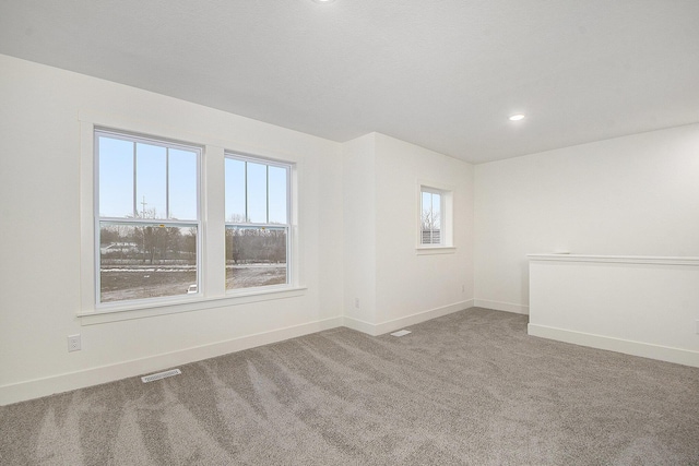 carpeted empty room featuring recessed lighting, visible vents, and baseboards