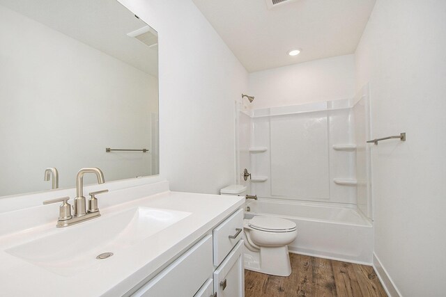 bathroom featuring toilet, tub / shower combination, wood finished floors, and vanity