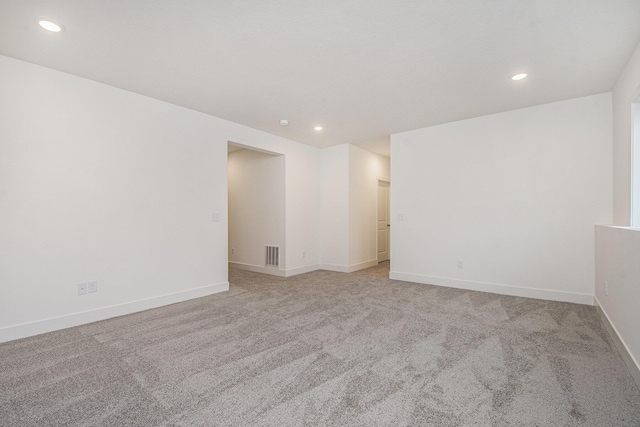 carpeted empty room featuring recessed lighting, visible vents, and baseboards