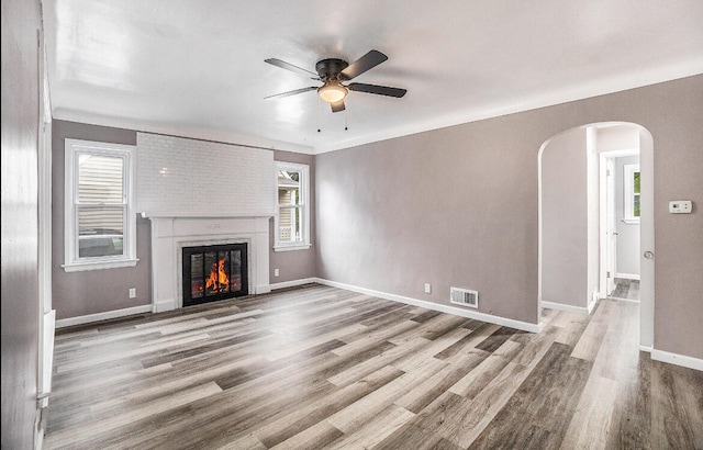 unfurnished living room with a fireplace, light hardwood / wood-style floors, and ceiling fan