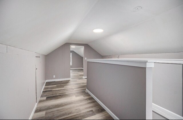 additional living space featuring hardwood / wood-style floors and lofted ceiling