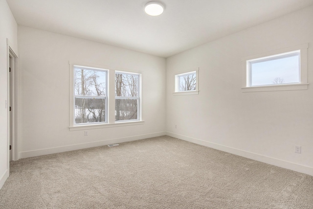 spare room with visible vents, baseboards, and carpet flooring