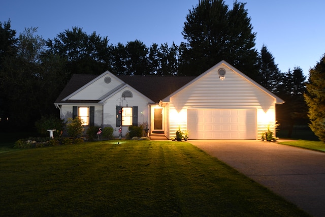 ranch-style house featuring a garage and a yard