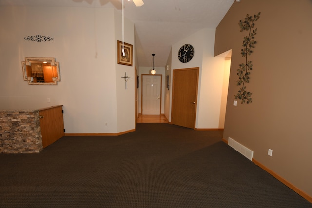 empty room featuring high vaulted ceiling, ceiling fan, and dark carpet