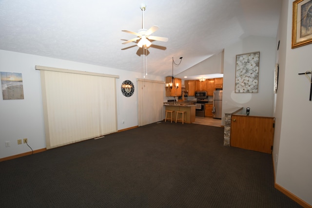 unfurnished living room featuring ceiling fan with notable chandelier, lofted ceiling, and dark colored carpet