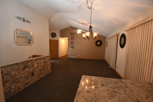 unfurnished dining area with ceiling fan, dark colored carpet, and vaulted ceiling