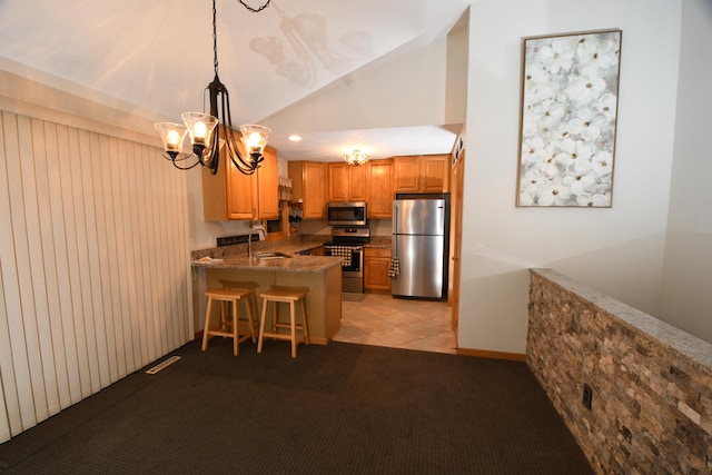 kitchen featuring appliances with stainless steel finishes, hanging light fixtures, sink, a kitchen breakfast bar, and kitchen peninsula