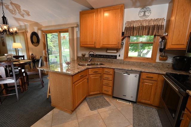 kitchen with kitchen peninsula, sink, light stone countertops, appliances with stainless steel finishes, and decorative light fixtures