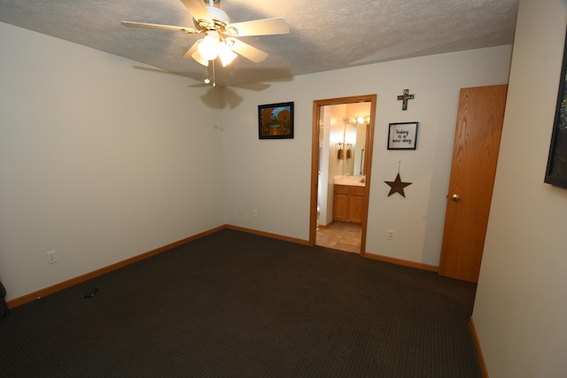 carpeted spare room featuring a textured ceiling and ceiling fan